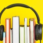 Audífonos con libros conceptualizando la ley de la música en Colombia