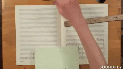 Animación de una mano escribiendo notas musicales en una partitura